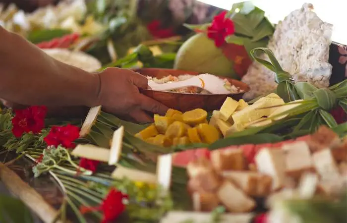 Déjeuner polynésien avec fruits frais et noix de coco servi sur des feuilles de palmier